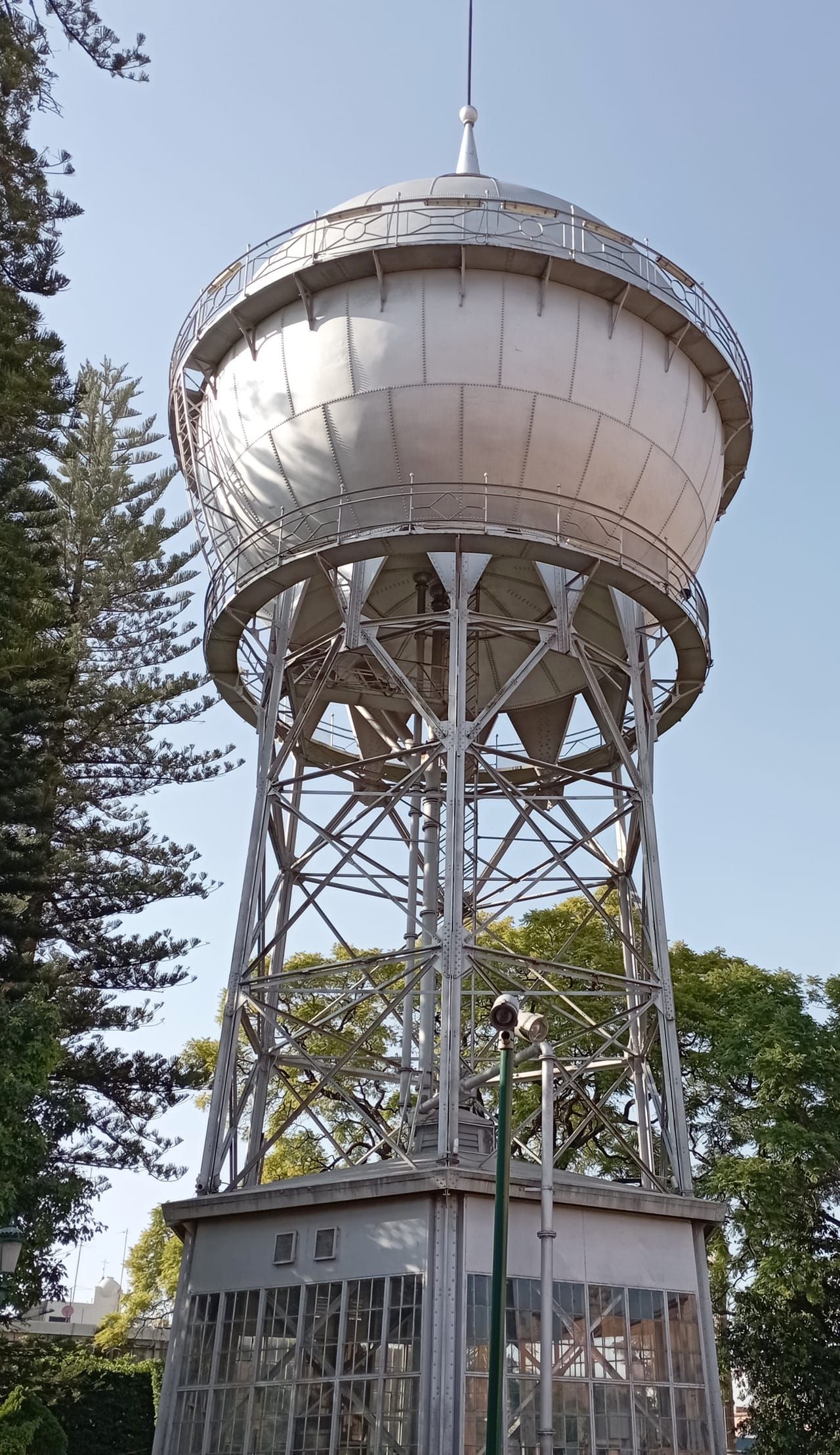 La Bola de Agua, torre de agua emblemática de Celaya, entre árboles y bajo un cielo despejado.